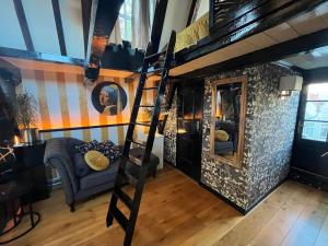 a room with a loft bed and a couch at The Enlightened House Luxury Suites in Amsterdam