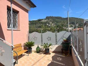 un balcón con un banco, plantas y una valla en Casa Marisa en Camporosso