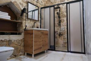 a stone bathroom with a shower and a sink at MİRSTONE TARİHİ KONAK in Mardin