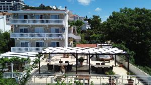 eine Terrasse mit Tischen und Stühlen vor einem Gebäude in der Unterkunft Sun Apartments in Ulcinj