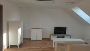 Southfork u Štěpánků - Apartmán Branišov : غرفة معيشة بيضاء مع تلفزيون ومكتب