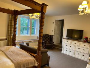 a bedroom with a canopy bed and a television at New Inn Hotel in Clapham