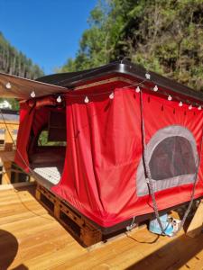 uma tenda vermelha sentada no topo de um deque de madeira em Dachzelt Cochem em Cochem