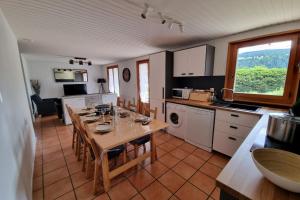 a kitchen with a table with chairs and a tableasteryasteryasteryasteryasteryastery at Le Petit Bois in Les Rousses