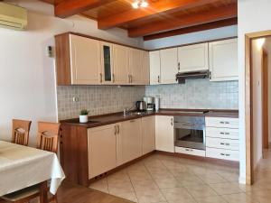 a kitchen with white cabinets and a sink at Apartment Anima 3 in Klimno