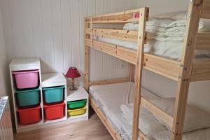 een houten stapelbed met kleurrijke bakken in een kamer bij Le Petit Bois in Les Rousses