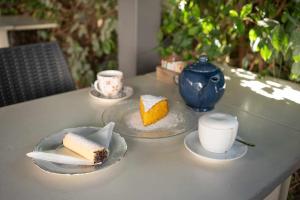 a table with two plates of cake and a cup of coffee at Domo Orise Alloggio in pieno centro in Orosei