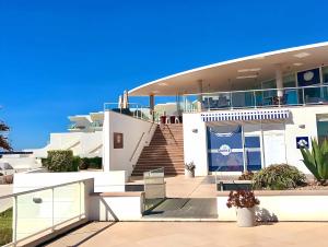 Un grand bâtiment blanc avec des escaliers se trouve juste devant. dans l'établissement Fantástico T2 vista mar e golfe e terraço privado, à Vau
