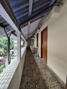 an internal corridor of a building with a hallway with chairs at Capital Hotel in Mumbai