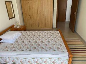 a bedroom with a large bed with a flowered blanket at Queen's apartment in Olympic Beach