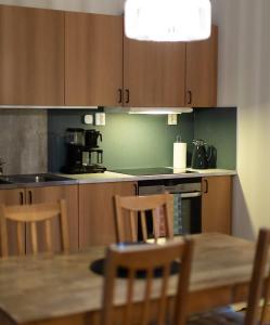 a kitchen with wooden cabinets and a table with chairs at The Studio in Skellefteå