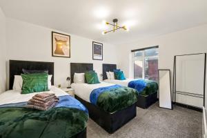 - une chambre avec 2 lits avec des draps verts dans l'établissement Beautiful and Stylish Yorkshire Apartment-Sleeps 5, à Castleford