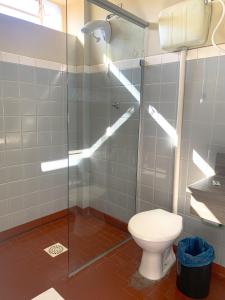 a bathroom with a toilet and a glass shower at Hotel Ideal in Chapecó