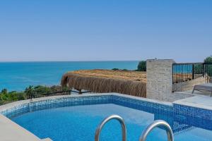 a swimming pool with a view of the ocean at Rosy Suites Hotel in Kuşadası