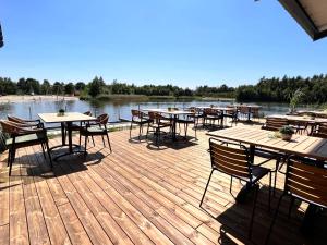 a deck with tables and chairs next to a river at EMSLAND-CAMP 