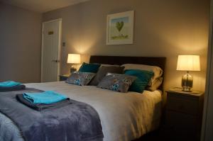 a bedroom with a large bed with blue pillows at Converted Stables at Peaceful Family Farm Stay in Pembrokeshire