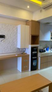 a kitchen with white cabinets and a counter top at Apartemen Uttara with Mountain View City Center in Kejayan
