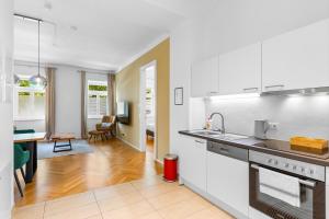 een keuken met witte apparatuur en een woonkamer bij Vienna Chic Residences #Suite 2 in Wenen