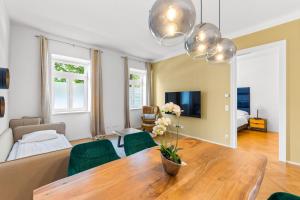 een woonkamer met een tafel en groene stoelen bij Vienna Chic Residences #Suite 2 in Wenen
