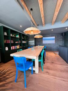 een eetkamer met een houten tafel en blauwe stoelen bij EMSLAND-CAMP 