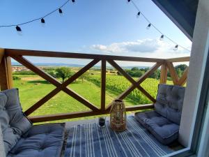 balcón con sofás y vistas a un campo en Holiday home Vinovilla, en Kutjevo