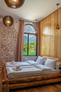 a bedroom with a large bed with a large window at Hotel Piano Kvareli in Kvareli