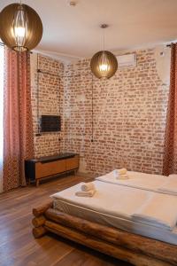 a bedroom with a bed and a brick wall at Hotel Piano Kvareli in Kvareli