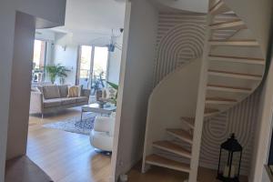 eine Treppe im Wohnzimmer mit Sofa und Wohnzimmer in der Unterkunft Appart 7P vue Seine, Tour Eiffel in Issy-les-Moulineaux