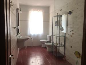 a bathroom with two toilets and a sink and a window at The reed in Mazzarino