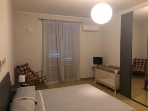a living room with a bed and a desk and a window at The reed in Mazzarino