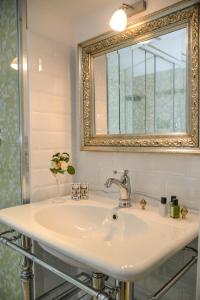 a bathroom with a sink and a mirror at Hotel Villa Rosenhof 1893 in Gardone Riviera