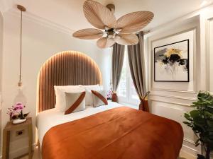 um quarto com uma cama grande e uma ventoinha de tecto em Luxury 2 Bedroom - Notre Dame em Paris