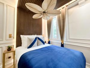 a bedroom with a blue and white bed and a ceiling fan at Luxury 2 Bedroom - Notre Dame in Paris