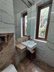 a bathroom with a sink and a window at Capital Hotel in Mumbai