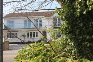 a large white house with windows on a street at Carbis Bay luxury ground floor flat close to beach in Carbis Bay