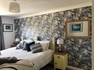 a bedroom with a bed with a floral accent wall at Carbis Bay luxury ground floor flat close to beach in Carbis Bay