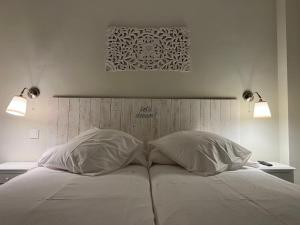 a bedroom with a bed with two pillows and two lights at Aljara Corredera in Córdoba