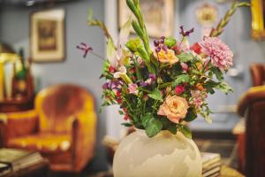 um vaso branco cheio de flores sobre uma mesa em The Classic by 2GO4 Grand Place em Bruxelas