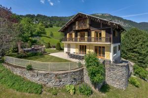 eine Luftansicht eines Hauses mit einer Steinmauer in der Unterkunft Maison Jaune, Alpes Travel, Ski in Ski Out, Sleeps 10 in Les Houches