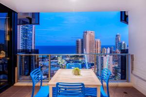 een tafel en stoelen op een balkon met uitzicht op de stad bij Converted Two Bedroom Apartments at Circle on Cavill - Self Contained, Privately Managed in Gold Coast