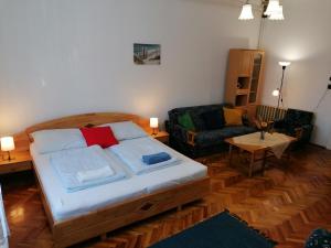 a bedroom with a bed and a living room with a couch at Hanna 3 Apartman in Kőszeg