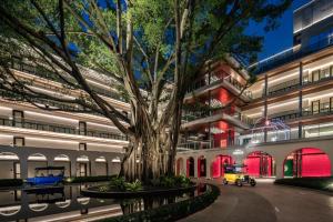 a large building with a tree in front of it at Hotel Indigo Guangzhou Haixinsha, an IHG Hotel - Social hour at Flow - Free shuttle bus to exhibition center during Canton Fair period in Guangzhou