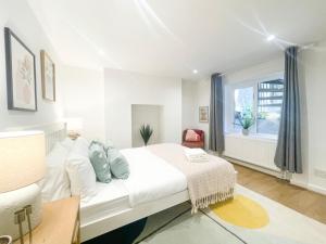Habitación blanca con cama y ventana en Sweet&Stylish 1 bed flat in CamdenTown en Londres