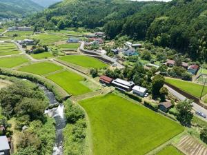 an aerial view of a village with a river at ファミリー向けの一棟貸切り別荘「セキデンファーム」 in Warao