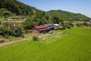 an aerial view of a farm with a field and a barn at ファミリー向けの一棟貸切り別荘「セキデンファーム」 in Warao