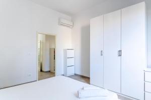 a bedroom with white cabinets and a large mirror at Livorno- Lungomare Viale Italia Bright Apartment! in Livorno