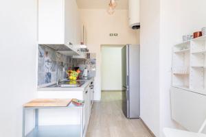 a kitchen with a sink and a refrigerator at Livorno- Lungomare Viale Italia Bright Apartment! in Livorno