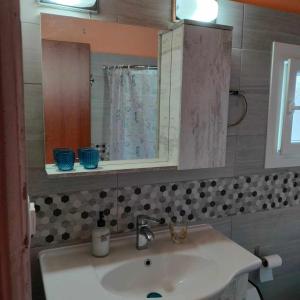 a bathroom with a sink with a mirror and a mirror at kali SunnySide Up in Nea Kalikratia
