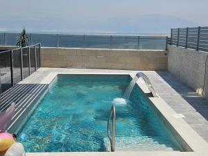 una piscina con una fuente de agua en un edificio en אל-ים המלח en Neve Zohar