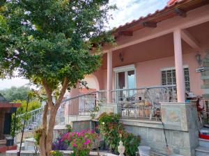 a pink house with a balcony and a tree at kali SunnySide Up in Nea Kallikrateia